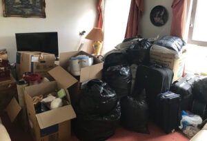 Boxes, black bags and suitcases packed up in a living room ready for a house clearance